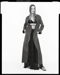 Model in long coat and patterned skirt against a white seamless background for Zara spring campaign