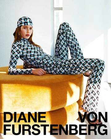 Model reclining on a yellow ottoman wearing a geometric patterned matching top, pants, and headscarf for Diane von Furstenberg.