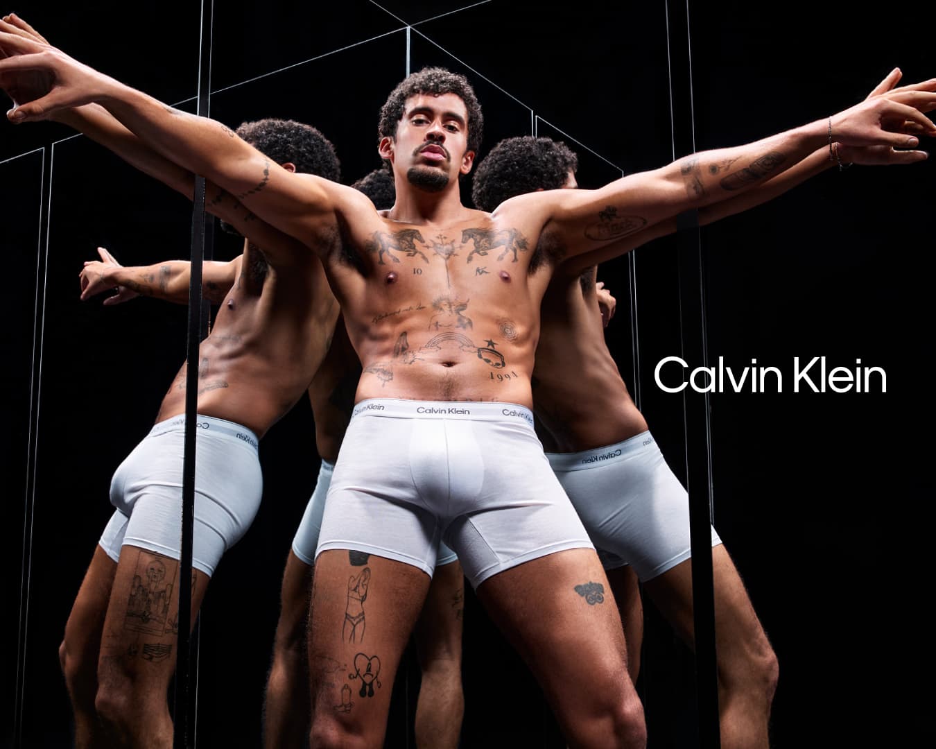 Bad Bunny wearing white boxer briefs posing among multiple mirrors for Calvin Klein Spring 2025 ad campaign