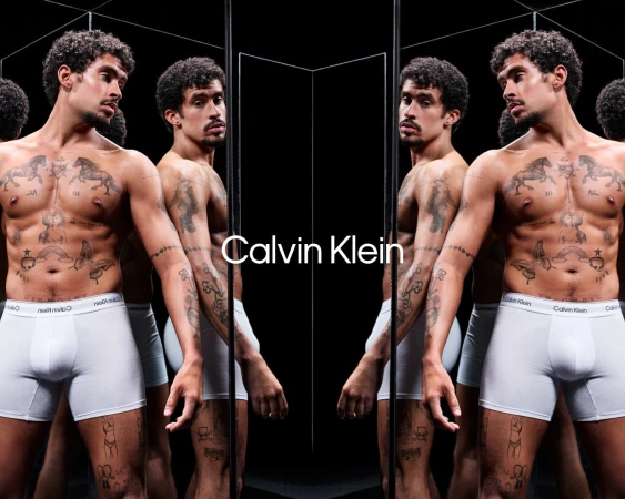 Bad Bunny shirtless wearing white Calvin Klein underwear in a reflective mirror installation for the Spring 2025 campaign