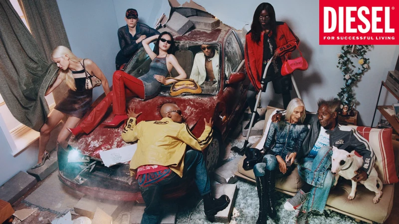 Group of models posed around a wrecked red car and a sofa indoors, featuring Diesel fashion campaign styling.