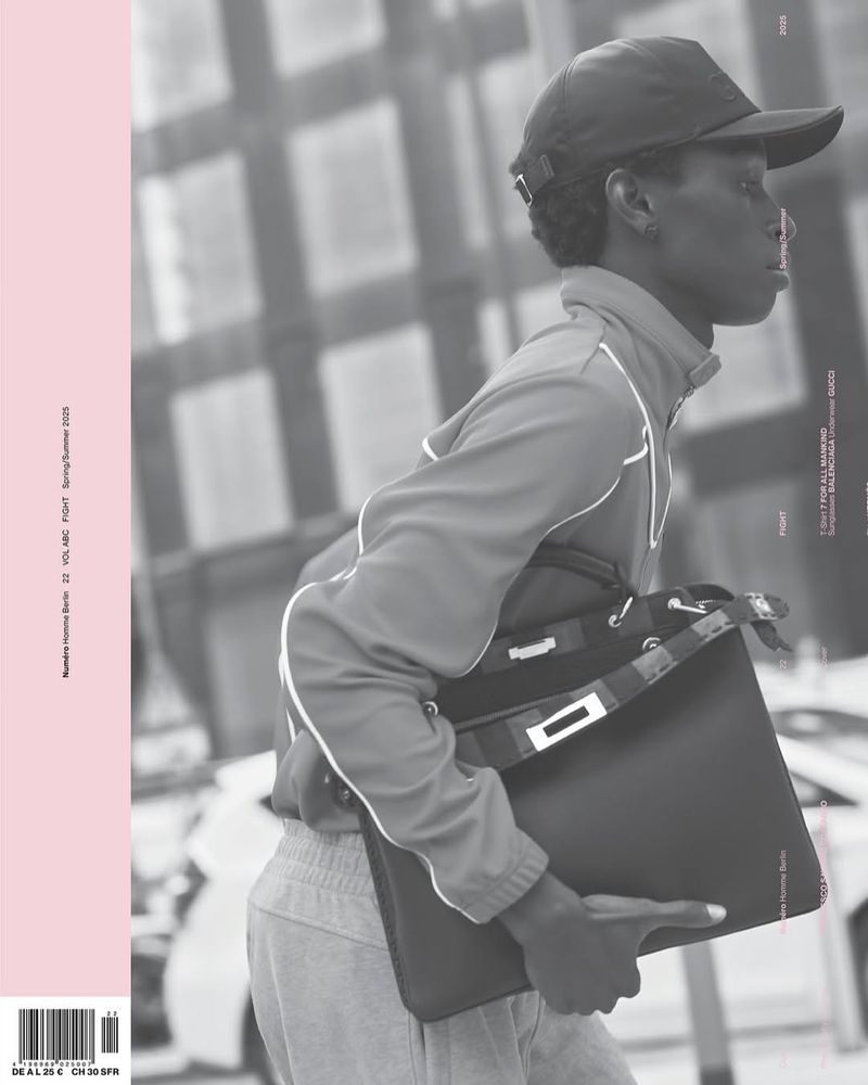 Magazine cover featuring a stylish person in athleisure wear carrying a tote bag in an urban setting, shot in monochrome.