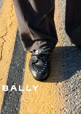 Close-up of black studded leather shoe on asphalt with yellow road markings for Bally spring ad campaign