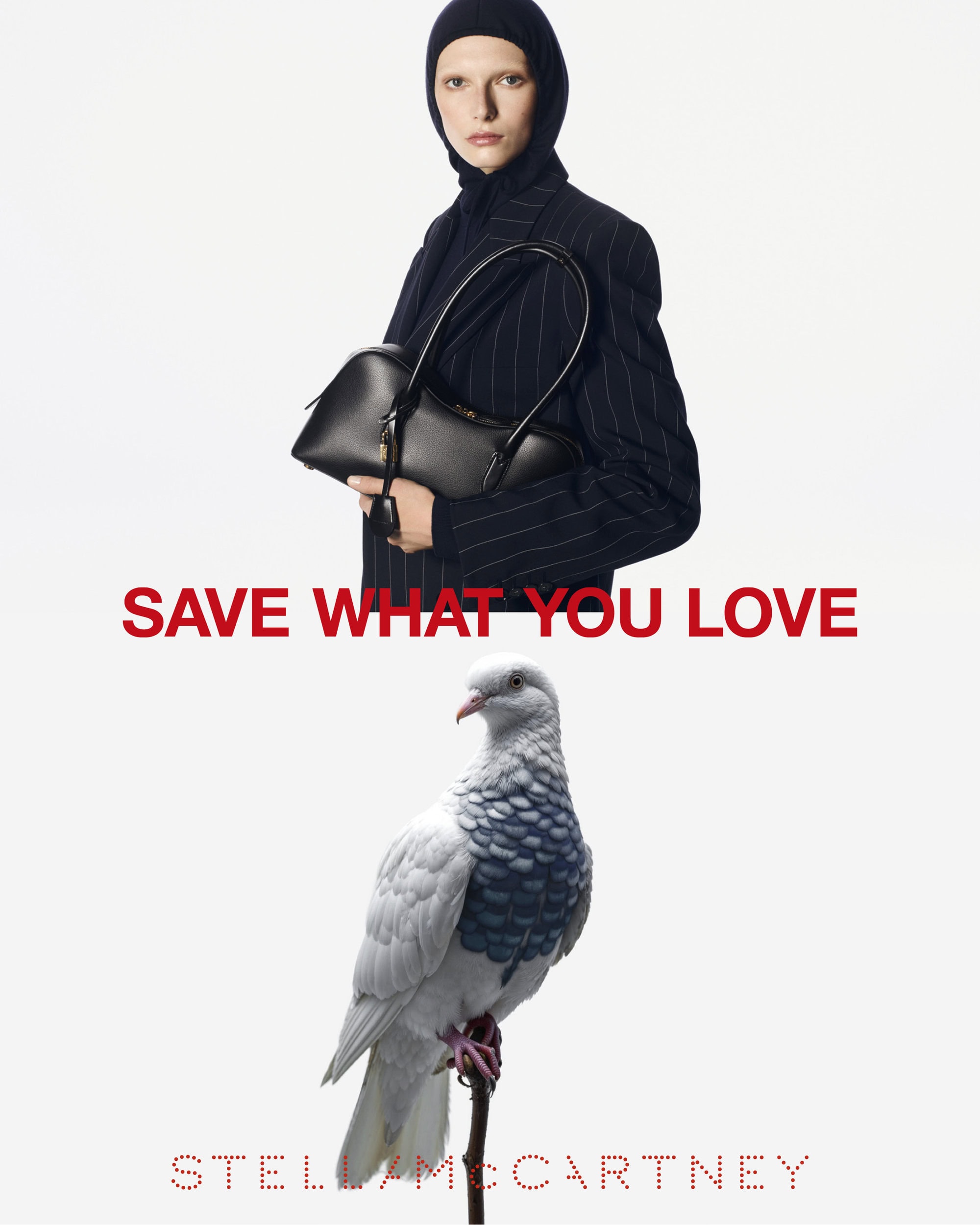 Model in dark pinstripe blazer wearing a black head covering holding a handbag, with a pigeon perched below against a white background.