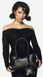 Model Myha'la holding a black leather handbag for Stella McCartney Spring 2025 campaign against a white backdrop.