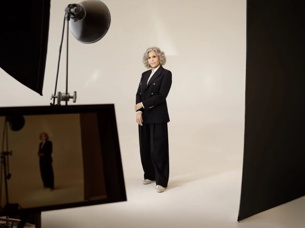 Jane Fonda standing in a studio wearing a black blazer and trousers for the Golden Goose campaign photographed by Maik Schuster