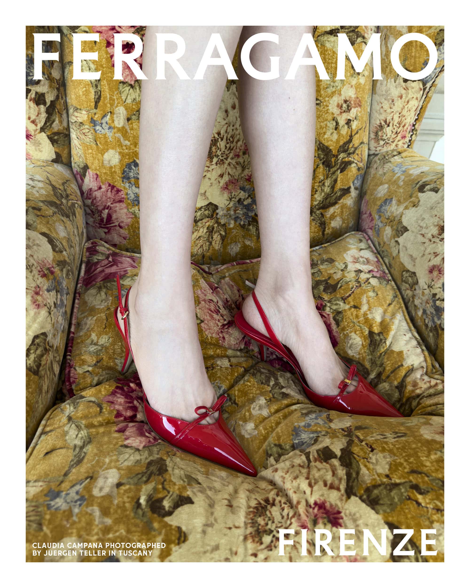 Close-up of legs wearing red slingback heels with small bows, seated in a yellow floral armchair for Ferragamo.