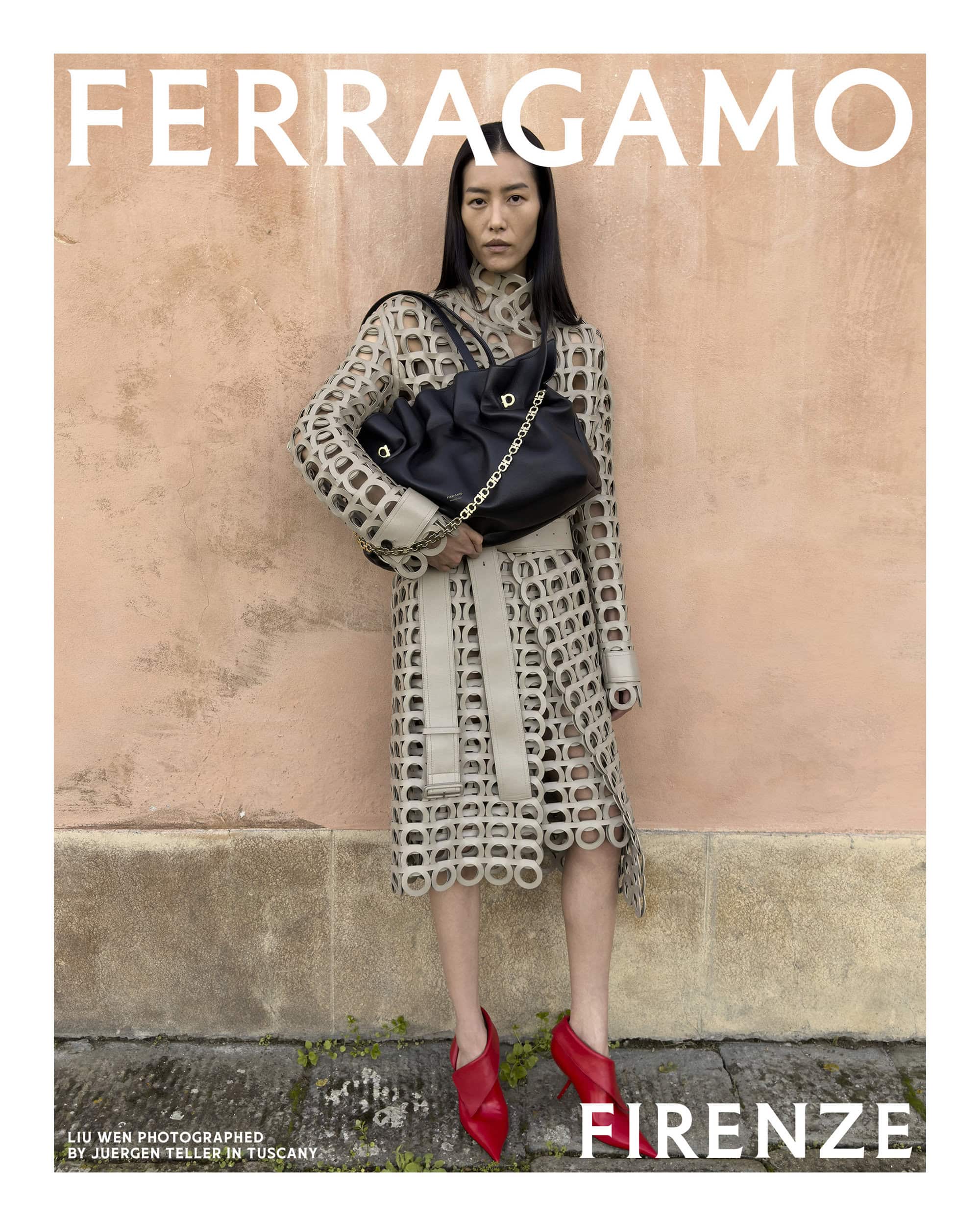 Liu Wen wearing a cut-out patterned coat and red heels holding a black handbag against a pink wall for Ferragamo.