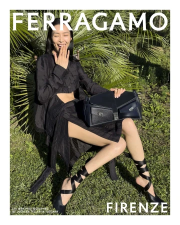 Model Liu Wen sitting on grass outdoors holding a black handbag for Ferragamo Spring 2025 ad campaign photographed by Juergen Teller