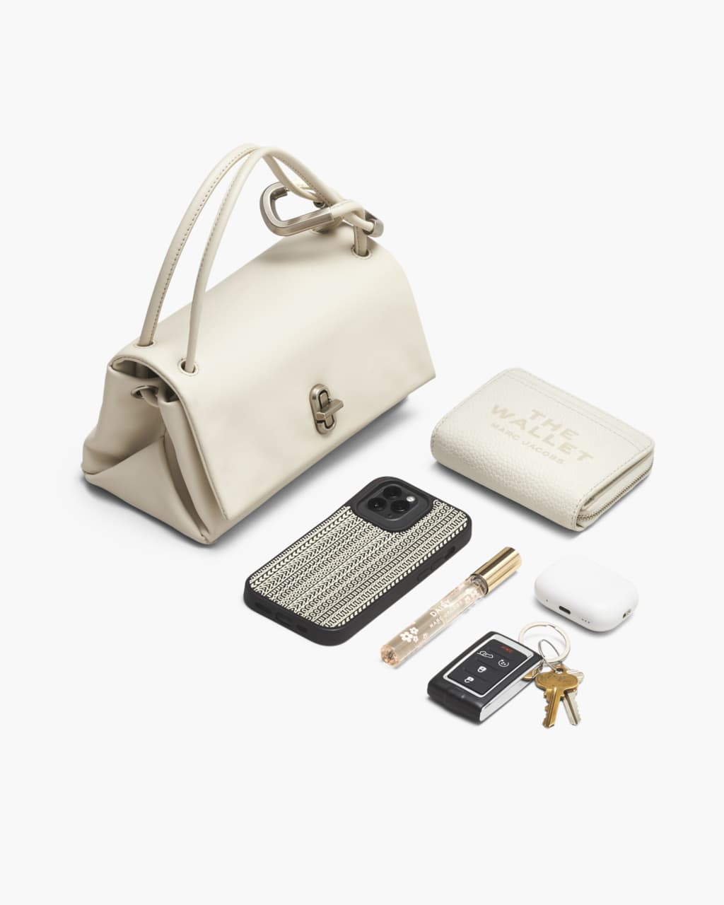 Off-white leather handbag arranged on a white background with accessories including a wallet, smartphone, keys, perfume, and earbuds.