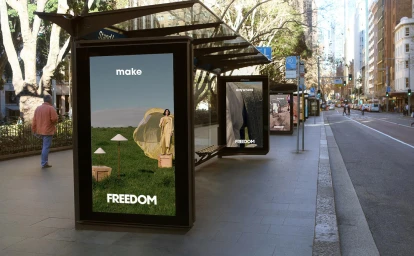 Digital advertising screens displaying Freedom brand campaign on a city street bus stop shelter