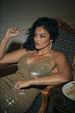 Model Devyn Garcia in a gold sequin dress sitting in an ornate armchair for the Nordstrom spring ad campaign