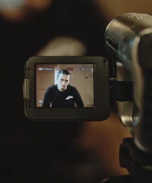 Close-up of a vintage camcorder LCD screen showing a man in a black t-shirt during the Dsquared2 campaign shoot