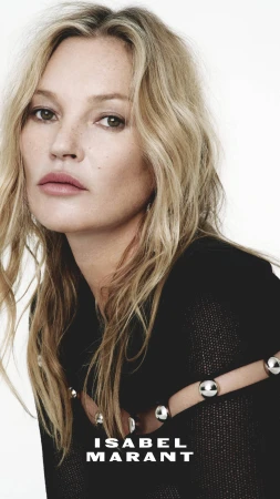 Portrait of Kate Moss wearing a black top with silver hardware against a white background for Isabel Marant