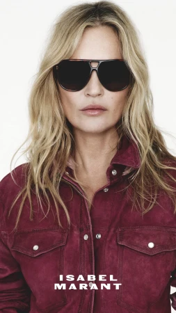 Kate Moss wearing dark sunglasses and a burgundy jacket for the Isabel Marant Spring 2025 ad campaign against a plain white background