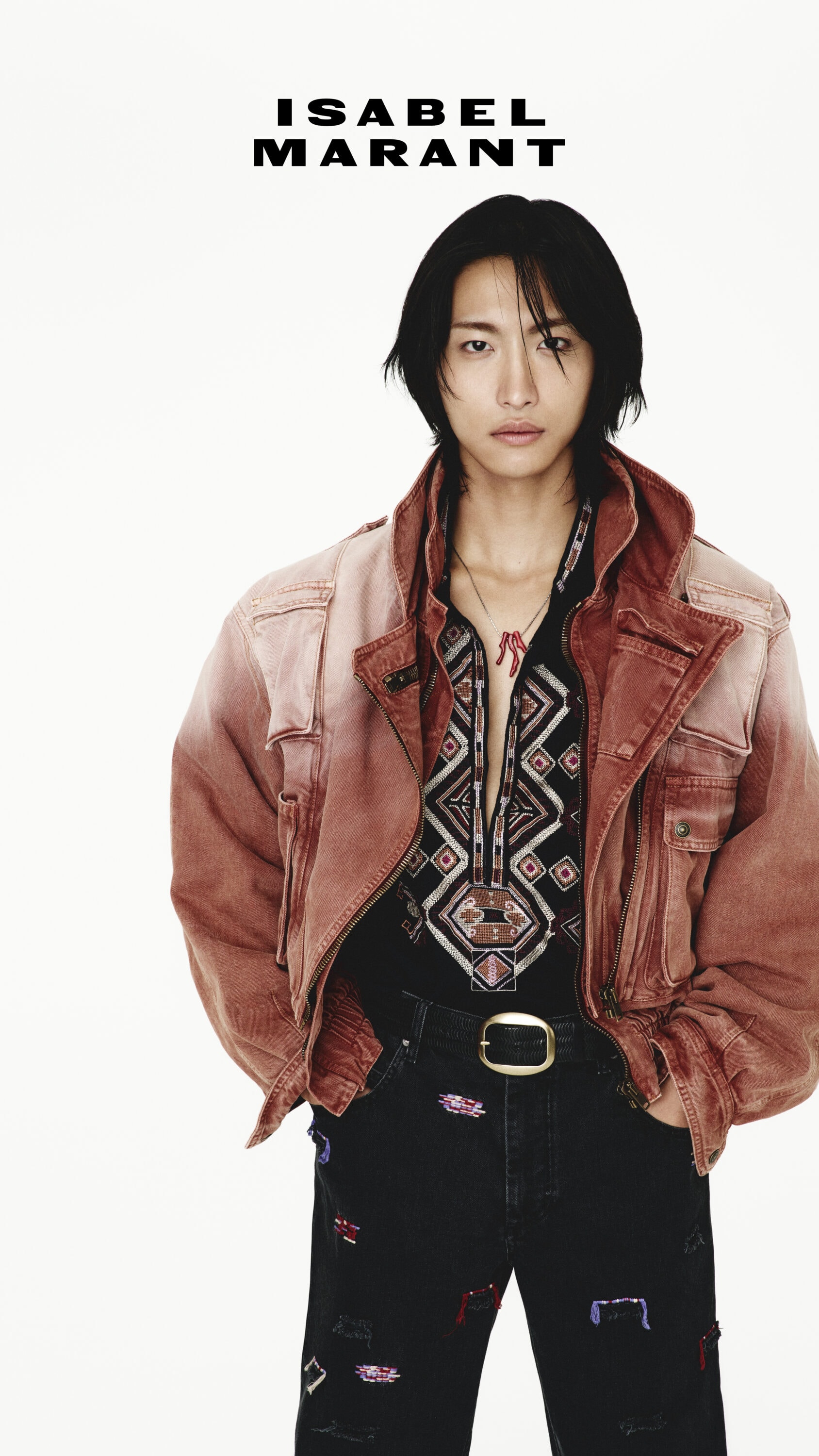 Model Seonghwa wearing a rust jacket and patterned shirt against a white seamless background for Isabel Marant