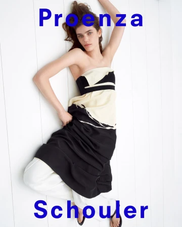 Model lying on white wooden floor wearing strapless black and ivory dress for Proenza Schouler