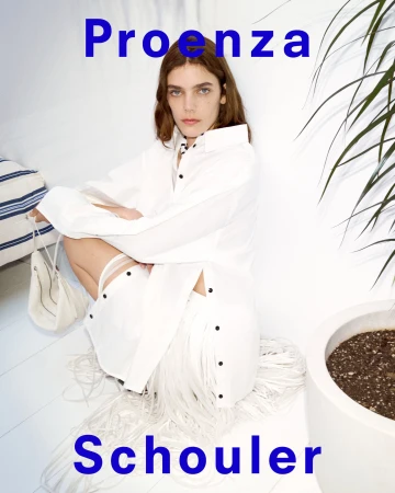Model crouching wearing a white buttoned shirt and fringe skirt with a white bag for Proenza Schouler