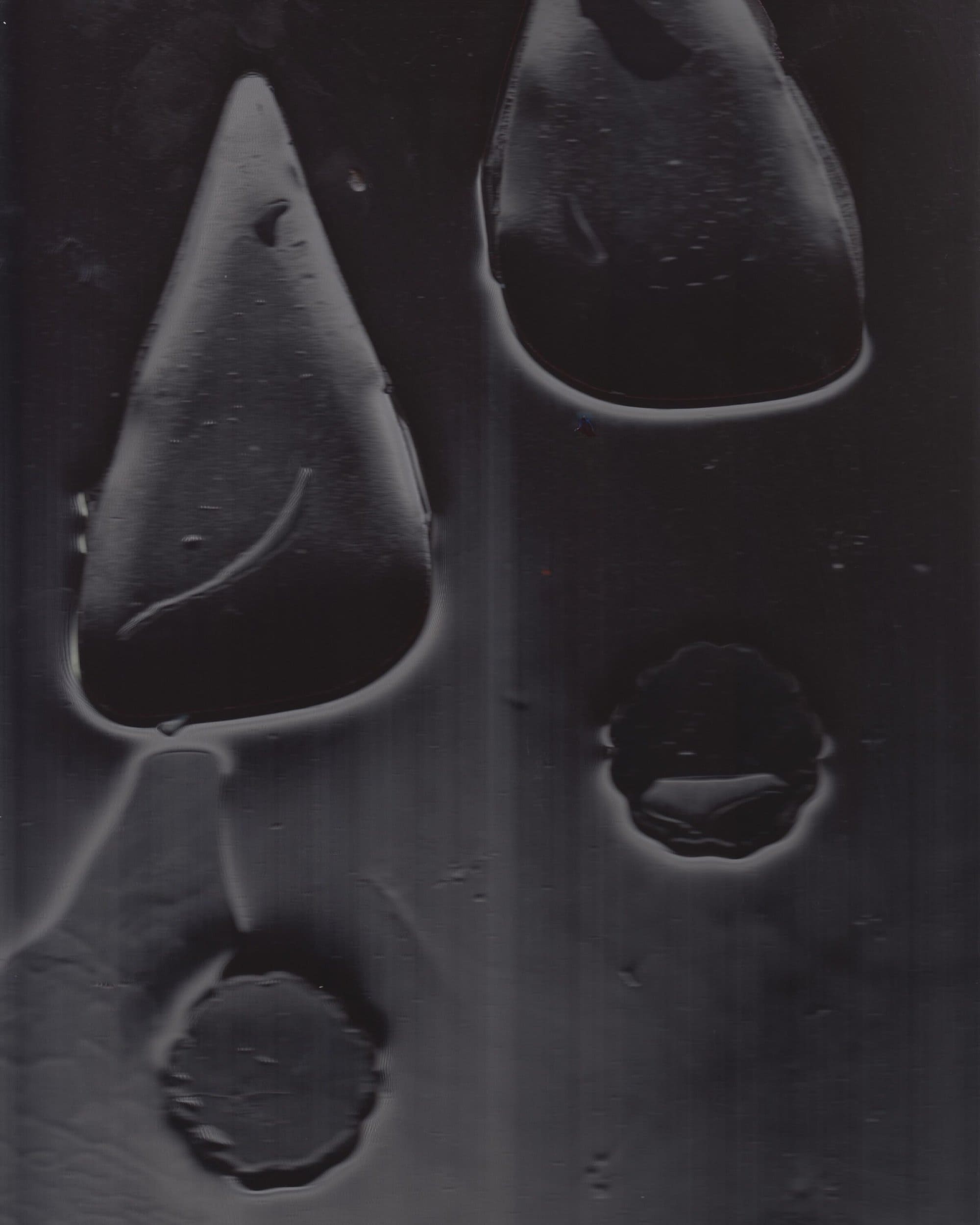 Close-up abstract shot with dark shapes and liquid forms against a textured background for Paul Andrew Spring 2025 campaign.