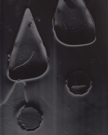 Close-up abstract shot with dark shapes and liquid forms against a textured background for Paul Andrew Spring 2025 campaign.