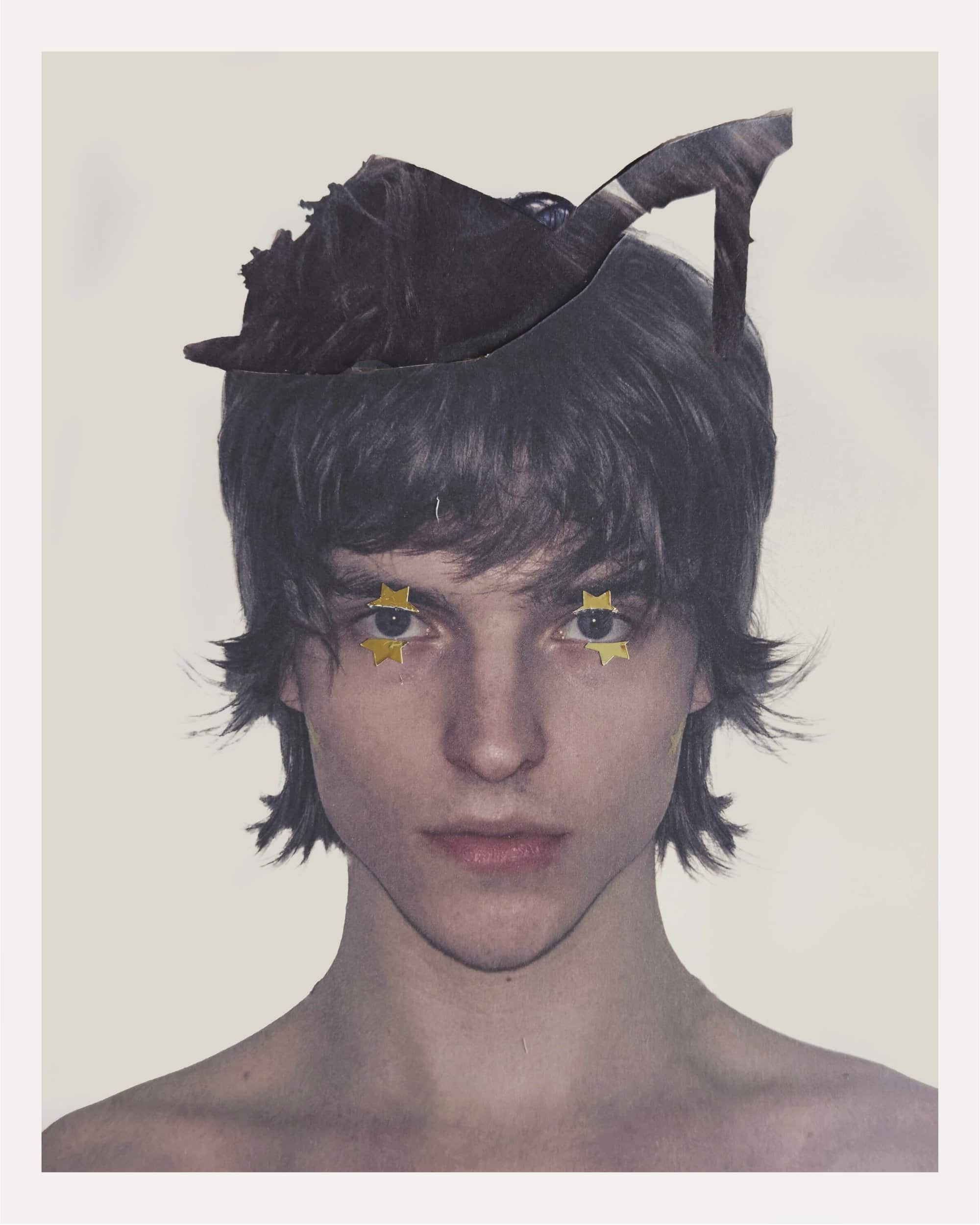 Portrait of a person with dark shaggy hair, small gold star eye decorations, and a cut-out high-heeled shoe resting on their head.