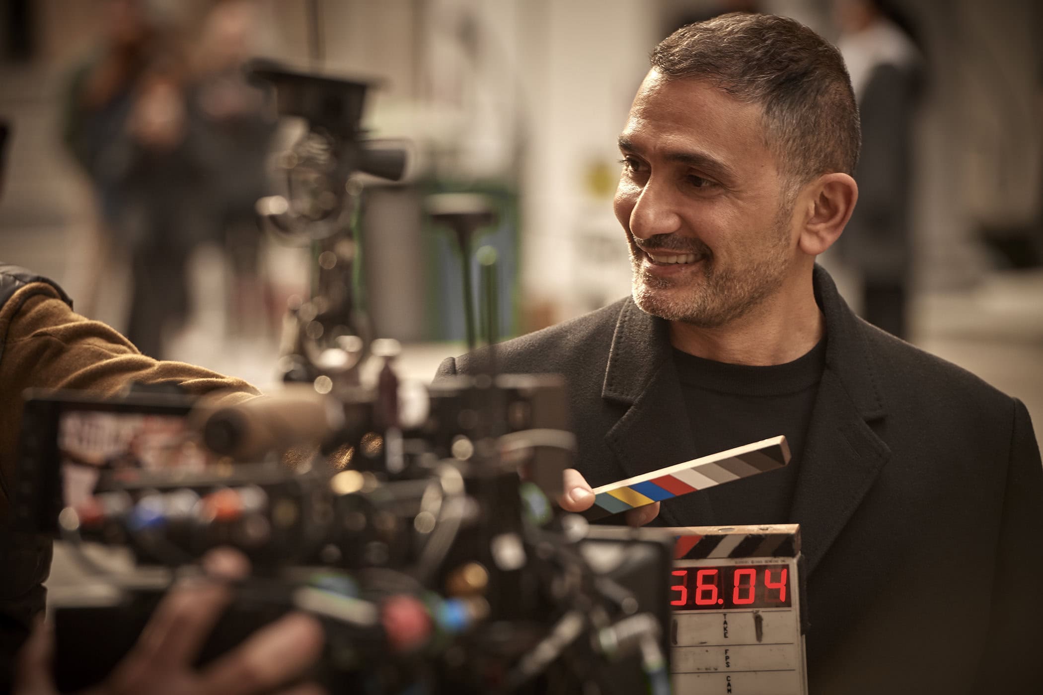 Francis Kurkdjian holding a clapperboard on set during the Dior Homme Parfum ad campaign production.