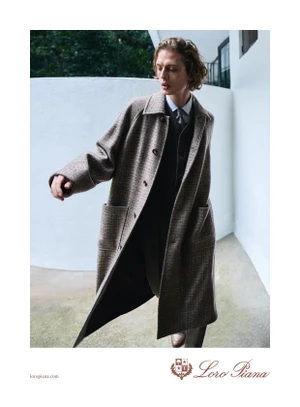 Model Leon Dame in a brown patterned coat for Loro Piana Spring 2025 ad campaign against a white architectural backdrop