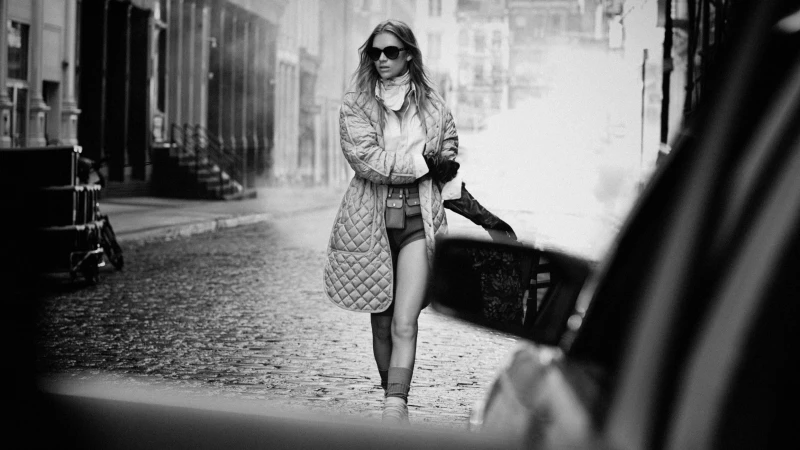 Model in quilted coat and sunglasses walking on a city street for Moncler Spring 2025 campaign