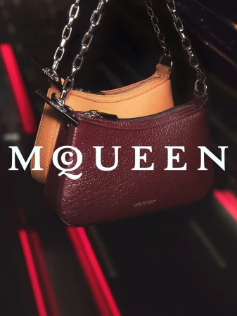 Two leather shoulder handbags with silver chain straps suspended against a dark red and black background