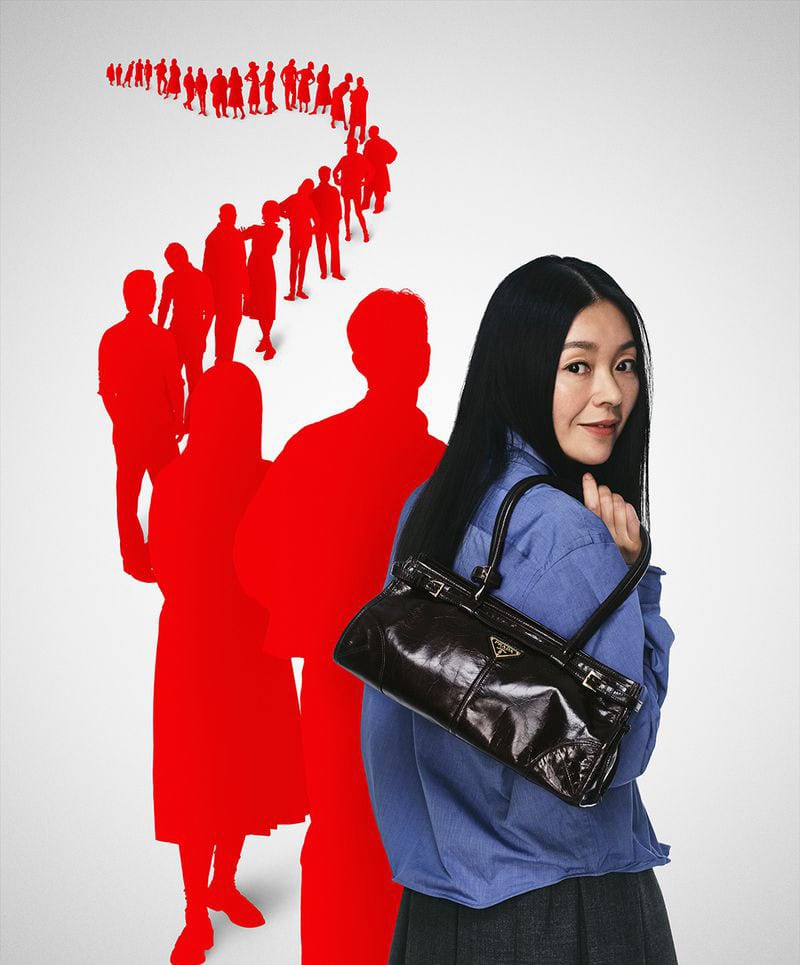 Woman in a blue shirt holding a dark leather handbag against a white background with a winding trail of red silhouettes