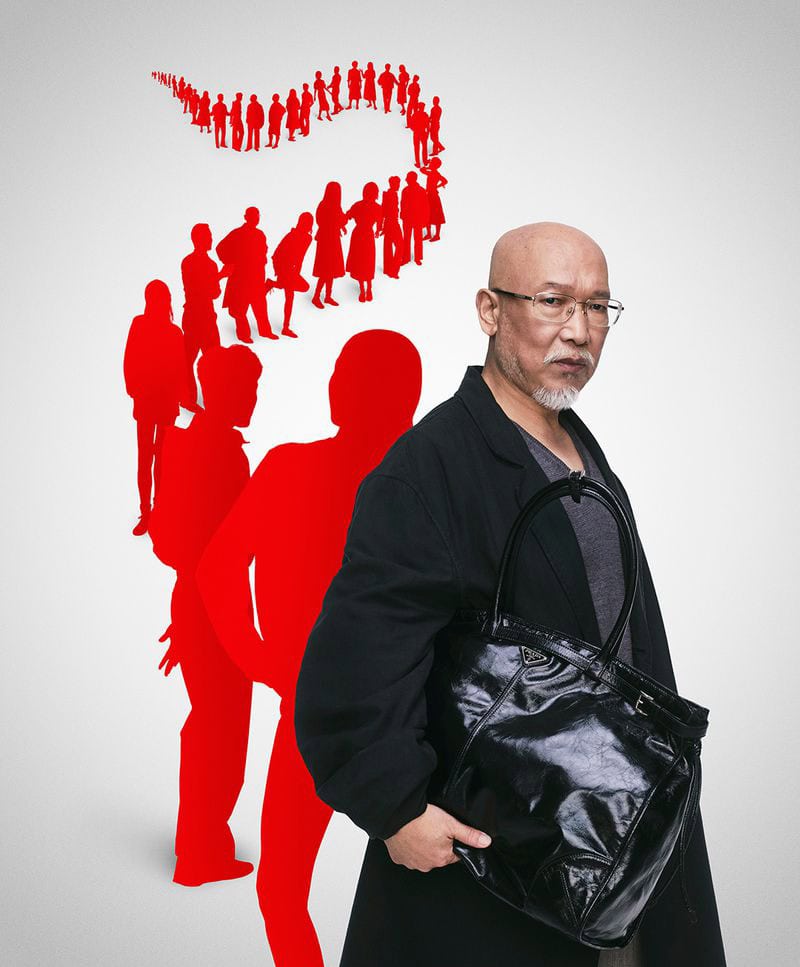 Bald man with glasses wearing a black coat holding a dark handbag against a white background with red silhouette figures