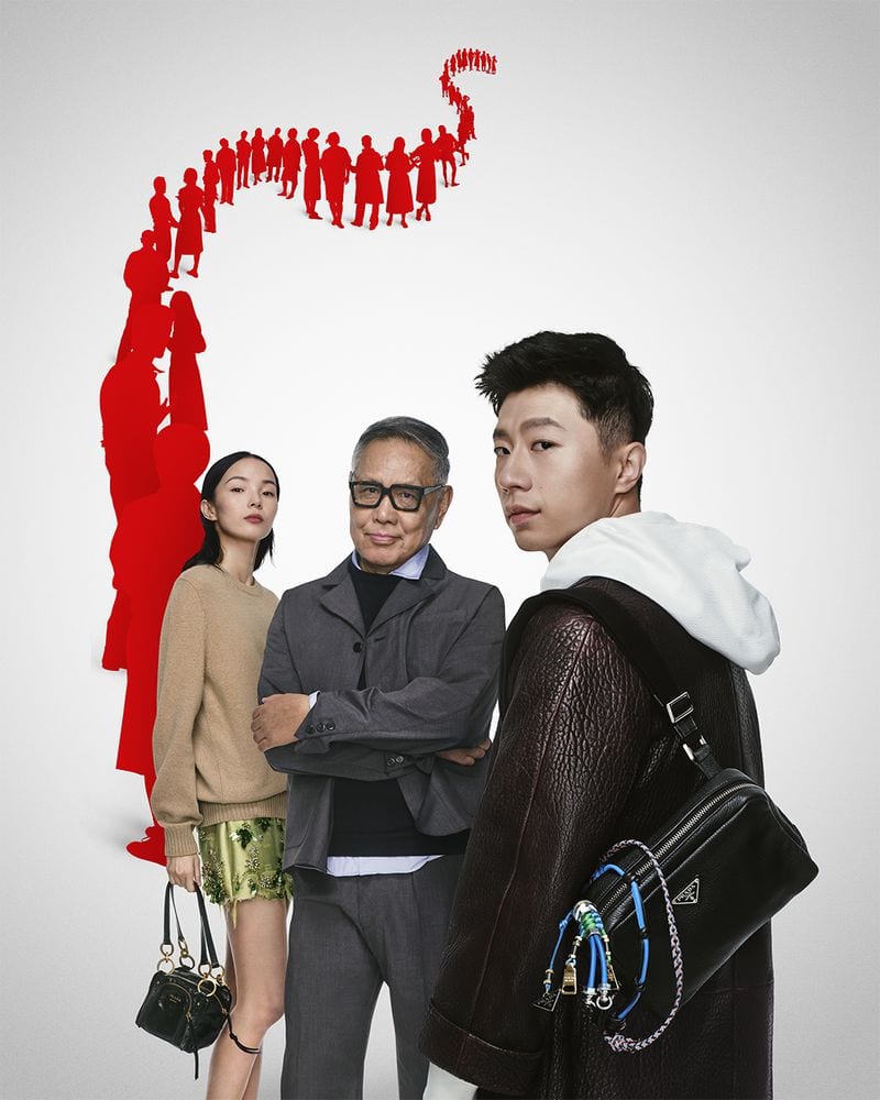 Three models posing against a white backdrop with a graphic red silhouette illustration above them for Prada campaign