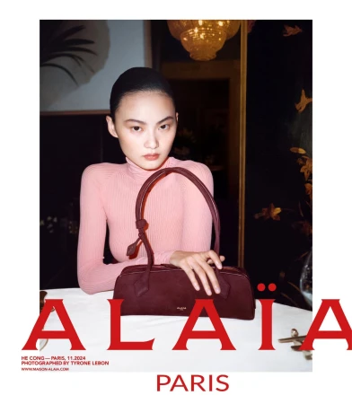 Model He Cong wearing a pink top holding a burgundy handbag for Alaia Lunar New Year campaign