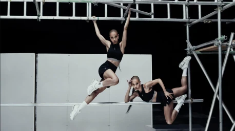 FKA Twigs wearing black athletic crop top and shorts posing dynamically on metal scaffolding for On Spring 2025 campaign