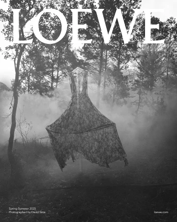 Monochrome black and white image of a lace dress suspended outdoors in a misty forest for the Loewe Spring 2025 ad campaign.