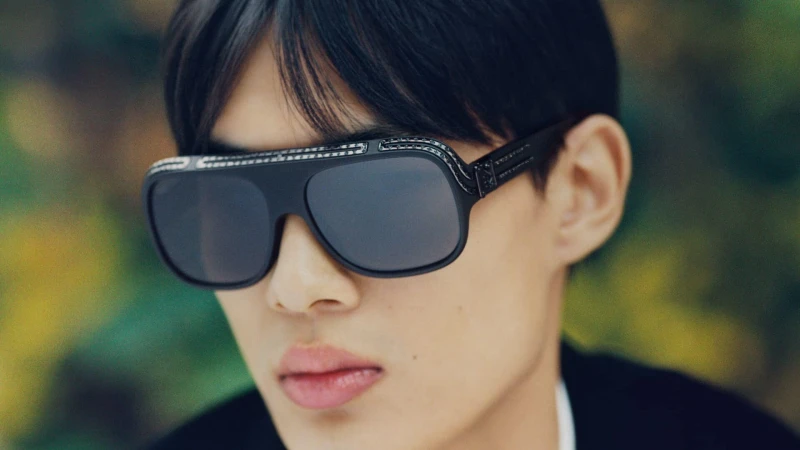 Close-up portrait of a man wearing dark sunglasses with detailed frames for Louis Vuitton Men's Spring 2025 ad campaign.