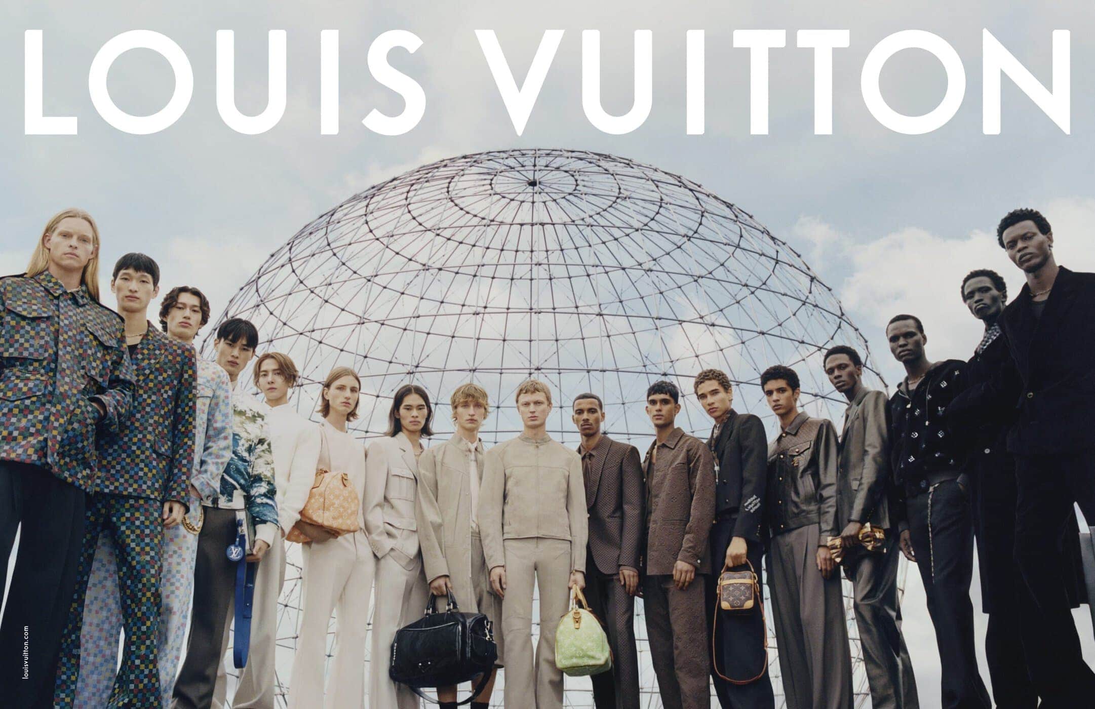 Group of male fashion models standing in a low angle shot in front of a large spherical architectural dome structure outdoors.