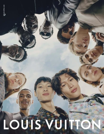 Group of diverse models looking down directly into the camera from a low angle against a bright sky.