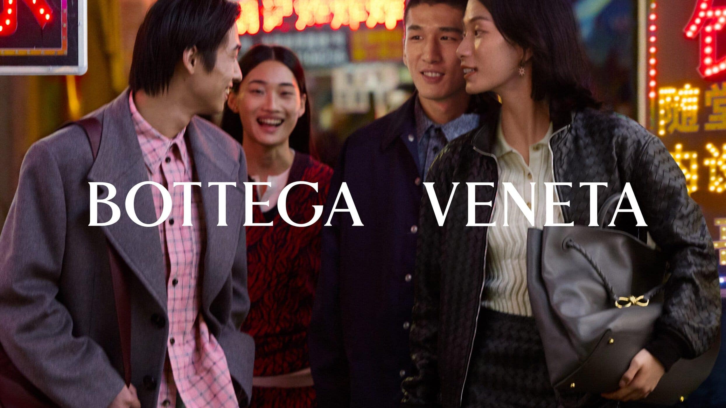 Four models walking together on a neon-lit street for the Bottega Veneta Lunar New Year 2025 campaign.