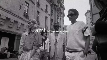 Black and white street fashion campaign image featuring models walking past classical European buildings.
