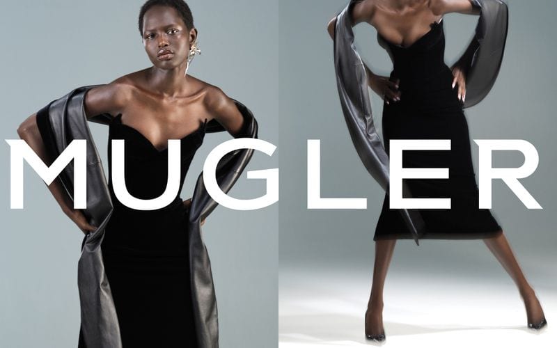 Model in a black strapless dress with a draped metallic grey stole against a grey backdrop in the Mugler Spring 2025 ad campaign