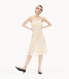 Carey Mulligan in a floral dress and black heels posing against a bright white background for Prada Spring 2025 campaign.