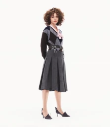 Carey Mulligan wearing argyle sweater and pleated skirt against a plain white background for Prada spring 2025 ad campaign.