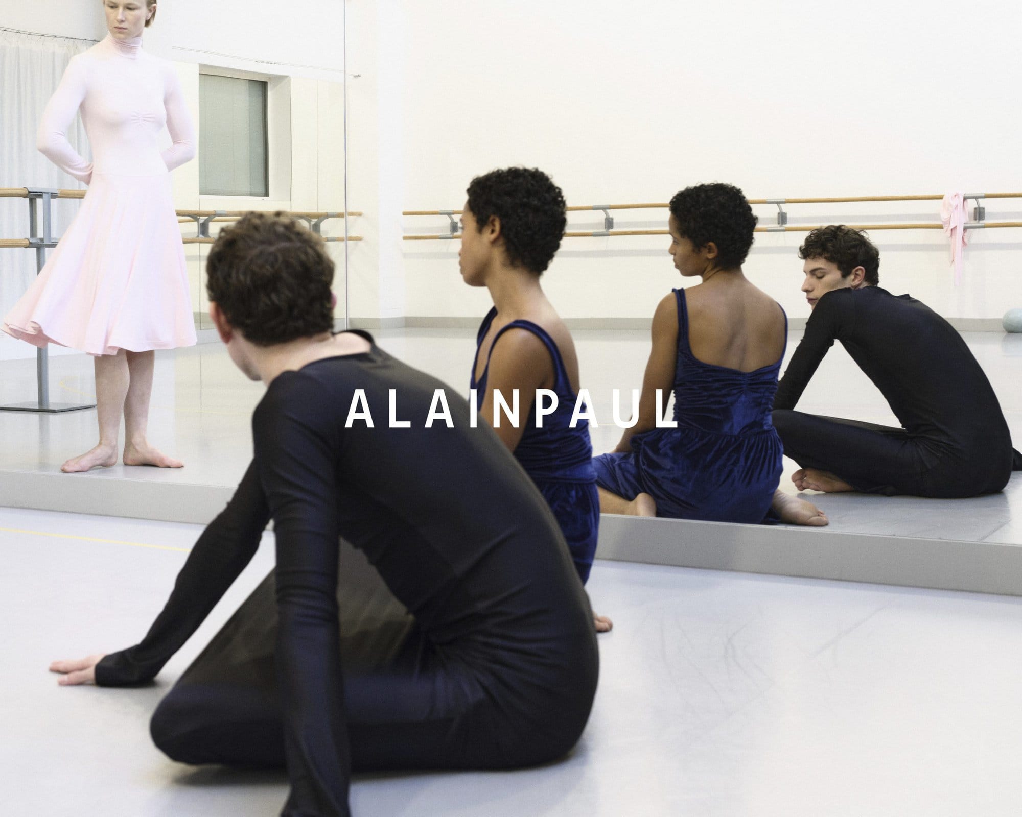Dancers in black and pink dancewear inside a ballet studio with mirrors and ballet barres for Alainpaul Fall 2024 Ad Campaign