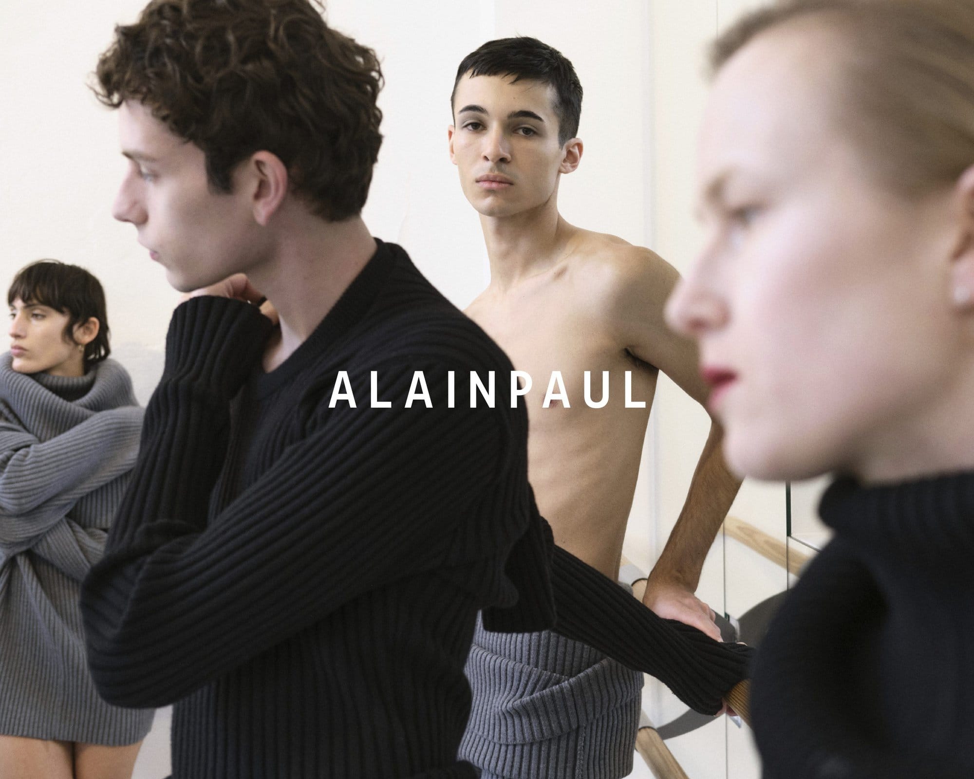Models in layered knitwear and neutral tones pose in an airy studio space for the Alainpaul Fall 2024 campaign.