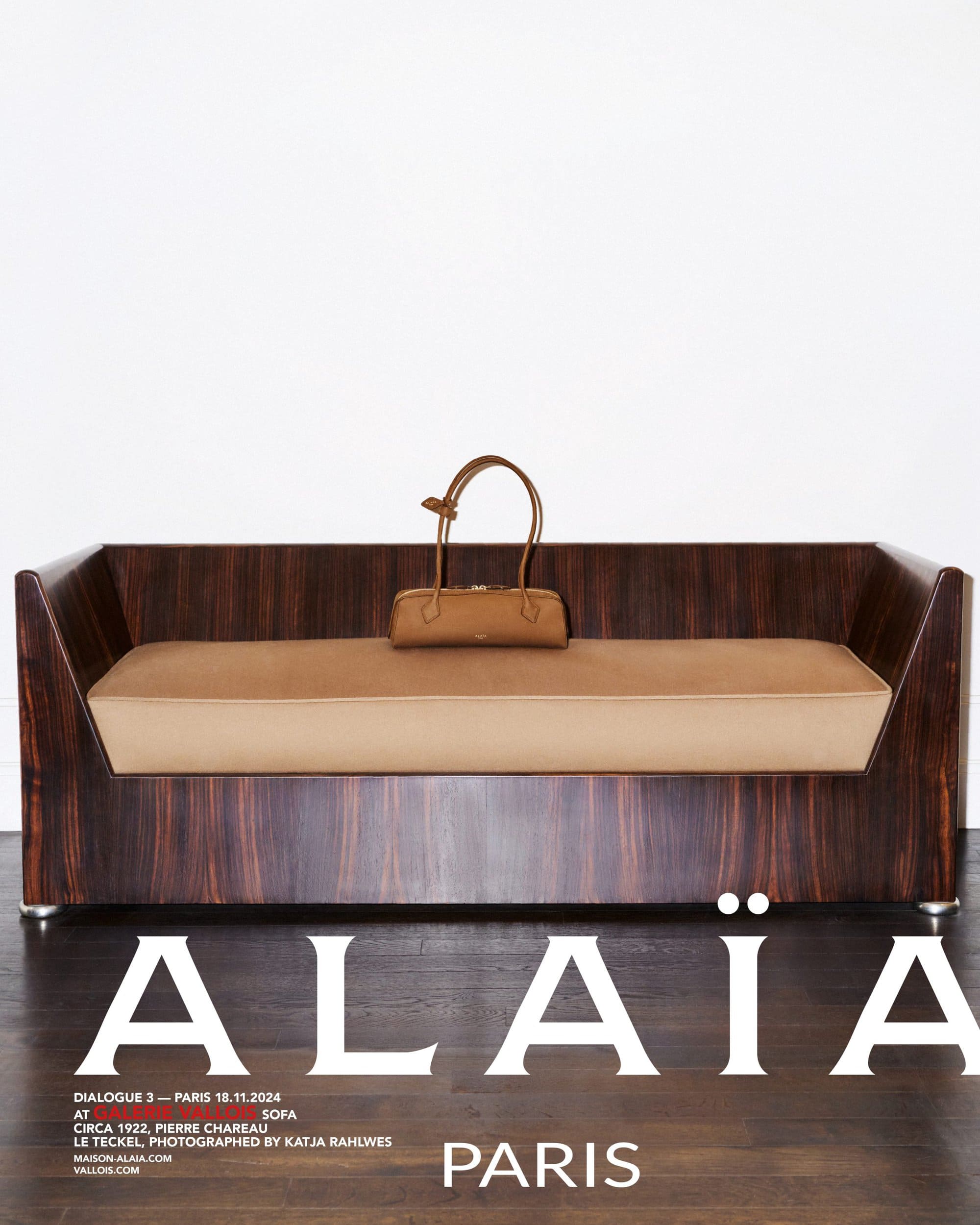 Brown leather handbag resting on a minimalist wooden sofa against a white wall for Alaia Fall 2024 campaign