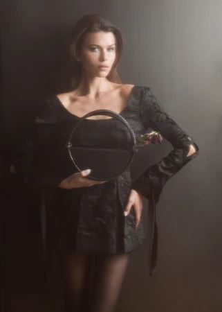 Model Georgia Fowler holding a round black handbag for Contessa Mills World Bag campaign photographed by Jacques Burga