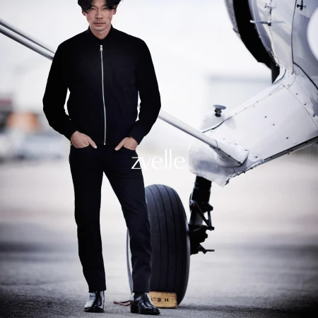 Man wearing a black zip jacket and black trousers standing next to a small aircraft wheel for Zvelle Alatus campaign