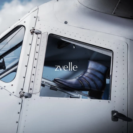 Blue leather ankle boot displayed inside the window of a white aircraft fuselage for the Zvelle Alatus campaign.