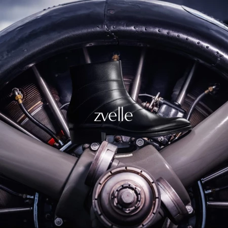 Black leather boot positioned against the mechanical hub of an aircraft engine for Zvelle's Alatus 2024 ad campaign